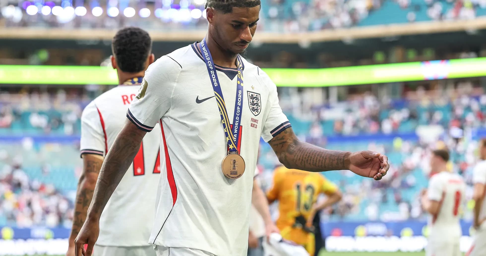 Jugador saliendo del campo con medalla de bronce Jugador saliendo del campo con medalla de bronce