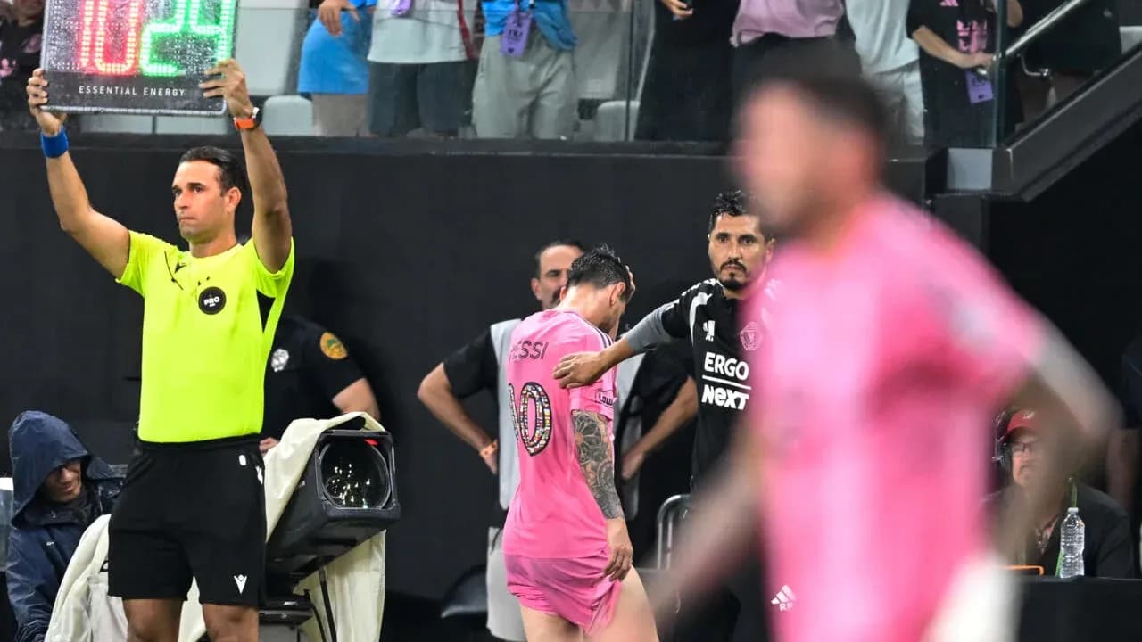 Jugador saliendo del campo con cartel de sustitución Jugador saliendo del campo con cartel de sustitución