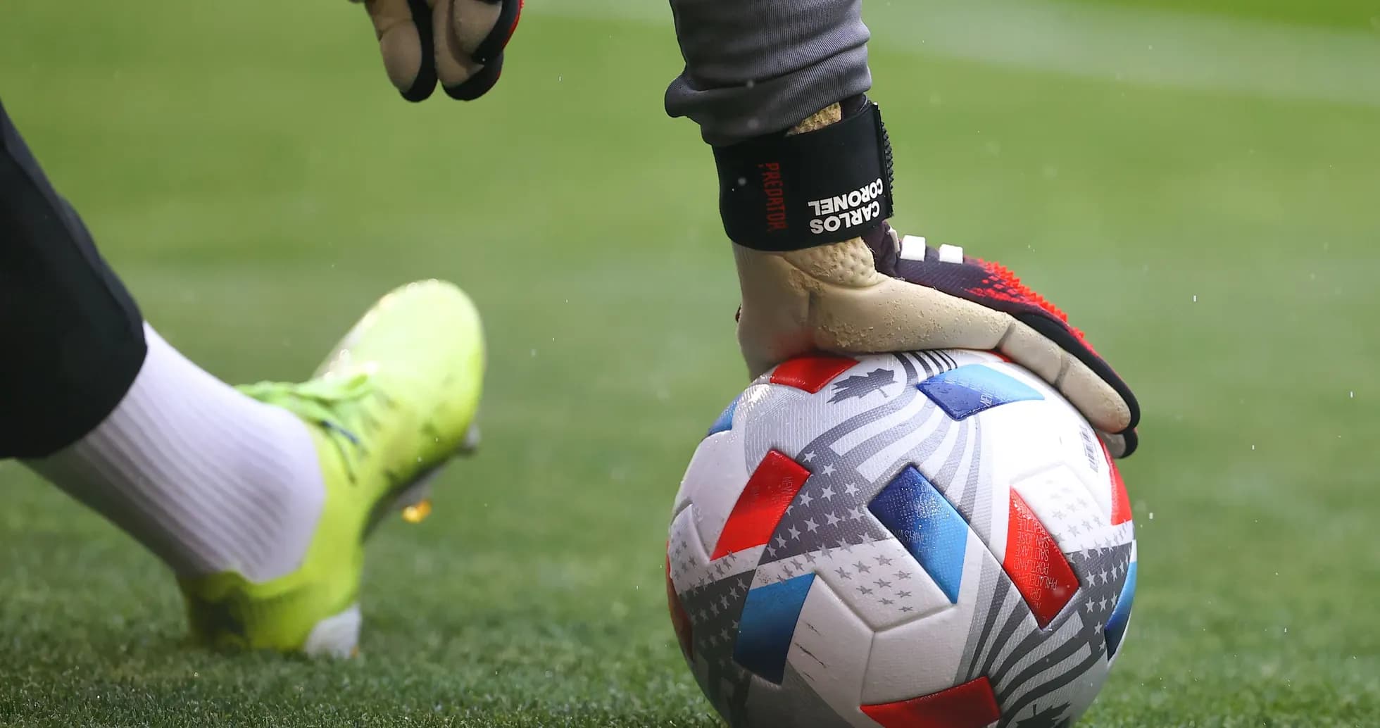 Portero sosteniendo un balón de fútbol en el campo Portero sosteniendo un balón de fútbol en el campo