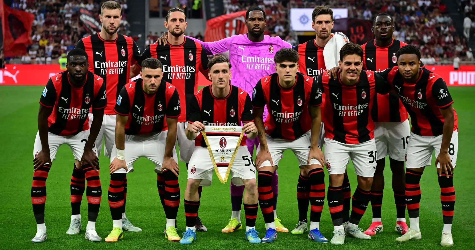 Equipo de AC Milan posando con trofeo en el campo Equipo de AC Milan posando con trofeo en el campo
