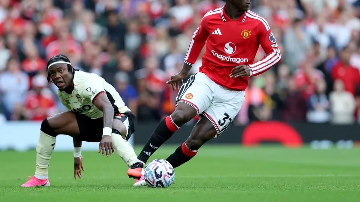 Jugador de Manchester United driblando a oponente Jugador de Manchester United driblando a oponente