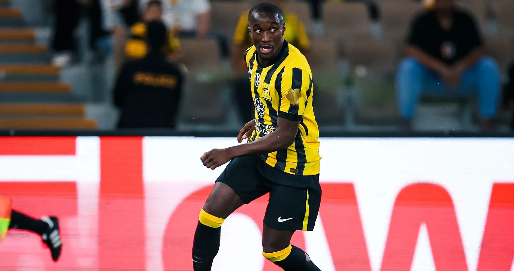 Jugador de Ittihad corriendo con el balón en el campo Jugador de Ittihad corriendo con el balón en el campo