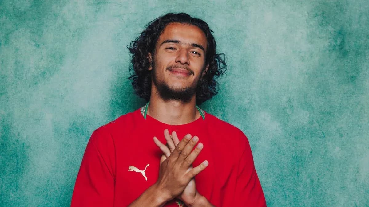 Jugador de fútbol con camiseta roja sonriendo Jugador de fútbol con camiseta roja sonriendo