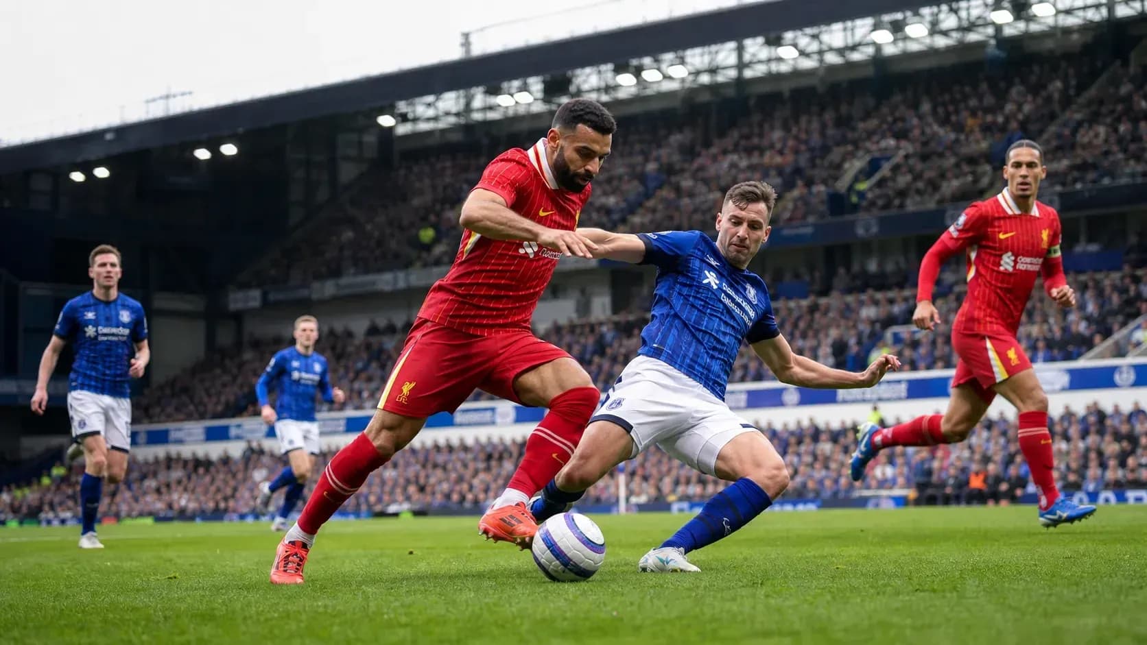 Jugador de Liverpool y Everton luchando por el balón Jugador de Liverpool y Everton luchando por el balón