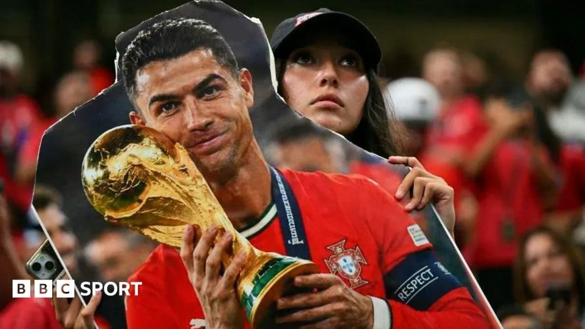Fan holding cutout of Cristiano Ronaldo with trophy Fan holding cutout of Cristiano Ronaldo with trophy