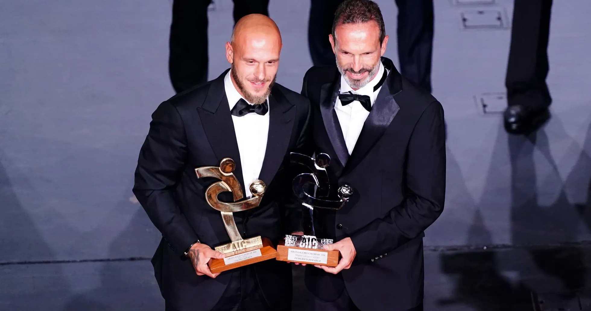 Dos hombres en trajes con premios en manos Dos hombres en trajes con premios en manos