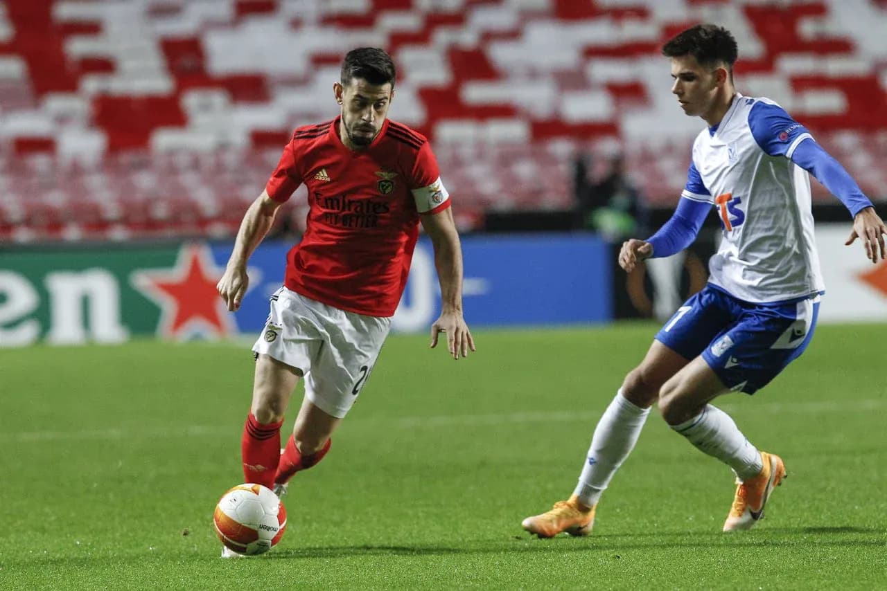 Jugador de Benfica driblando a oponente de Lech Poznan Jugador de Benfica driblando a oponente de Lech Poznan