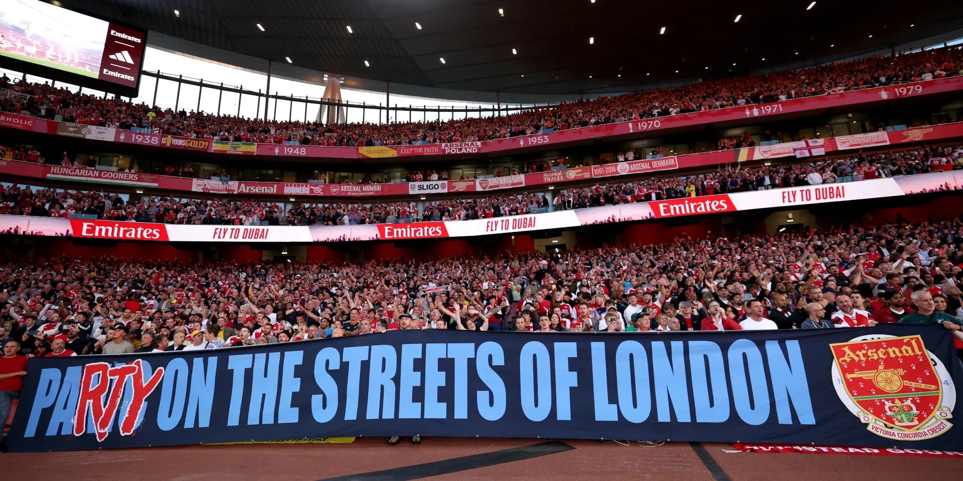 Aficionados de Arsenal con pancarta en el estadio Aficionados de Arsenal con pancarta en el estadio
