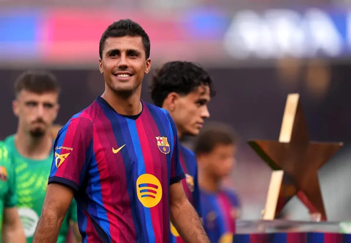 Jugador de FC Barcelona sonriendo con compañeros detrás Jugador de FC Barcelona sonriendo con compañeros detrás
