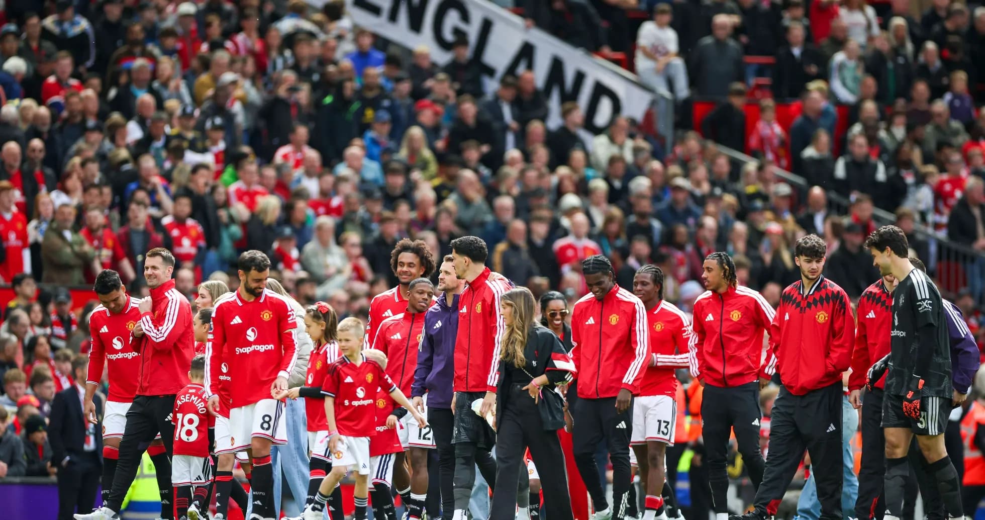 Jugadores de Manchester United en el campo con aficionados Jugadores de Manchester United en el campo con aficionados