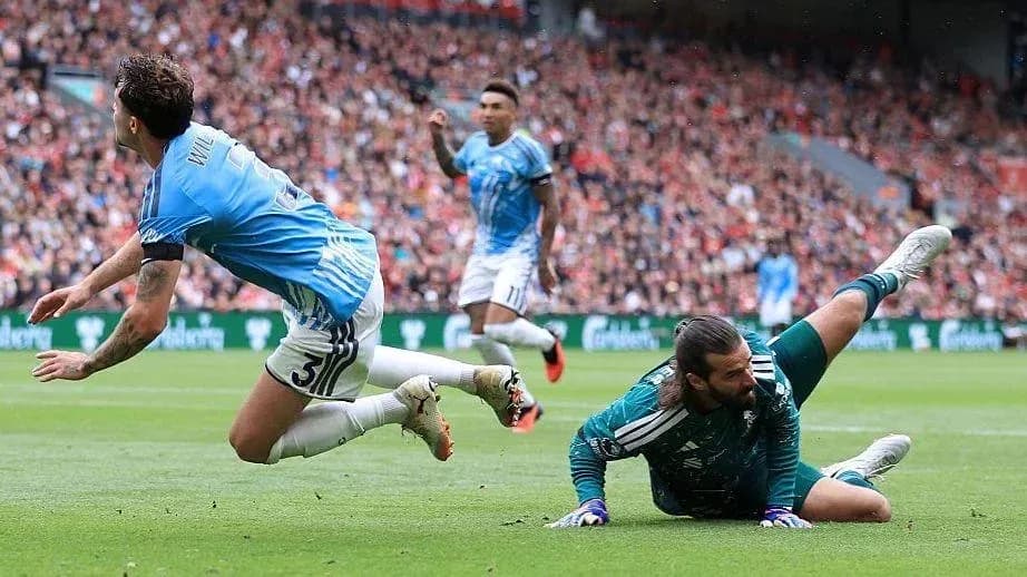 Jugador cae mientras el portero detiene el balón Jugador cae mientras el portero detiene el balón
