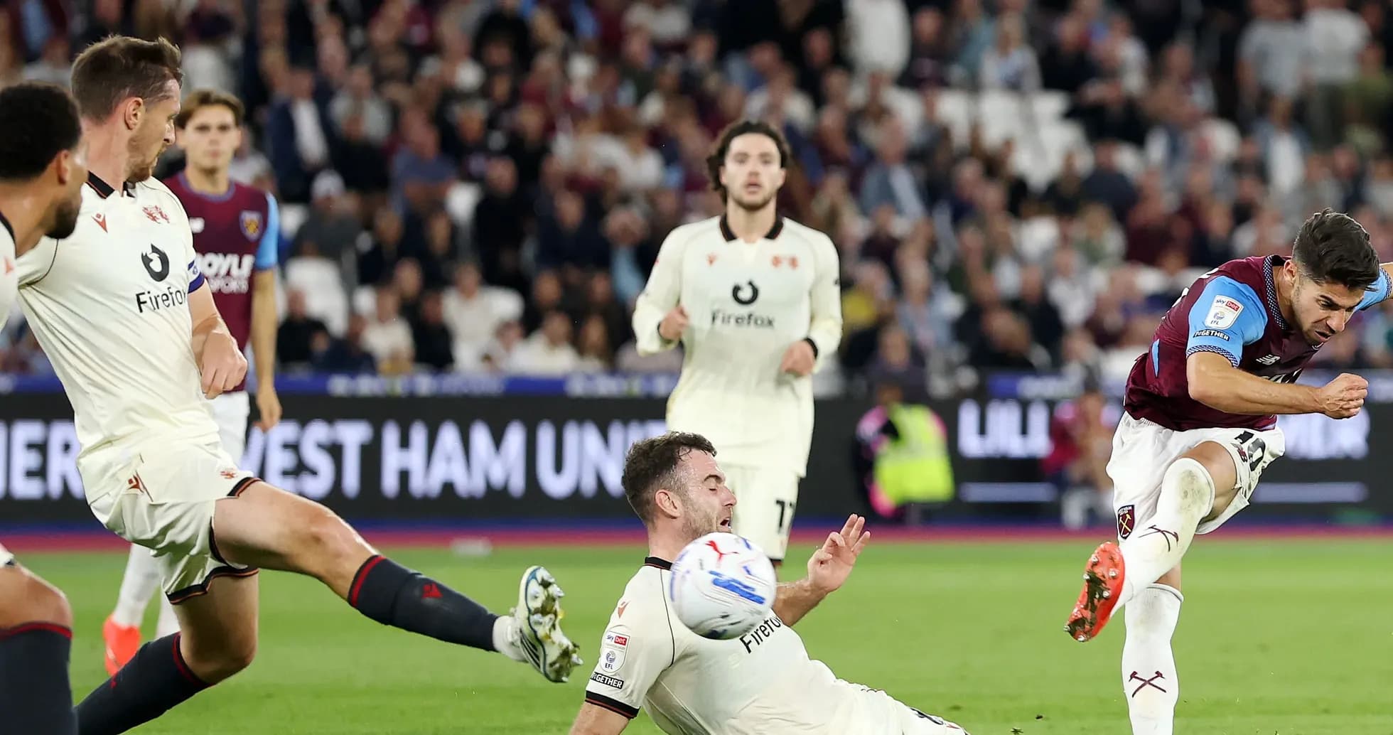Jugador de West Ham disparando mientras rival cae al suelo Jugador de West Ham disparando mientras rival cae al suelo