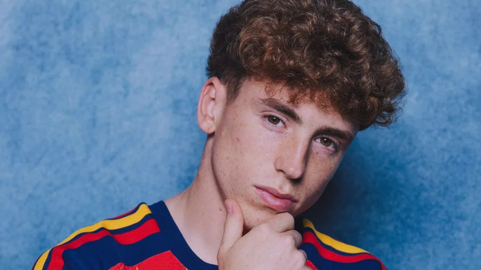 Joven con camiseta de rayas, fondo azul Joven con camiseta de rayas, fondo azul