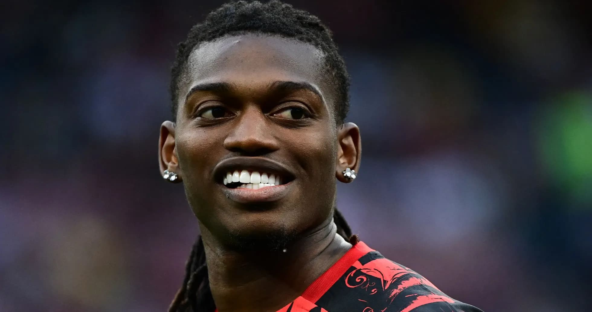 Jugador sonriendo con camiseta roja y negra Jugador sonriendo con camiseta roja y negra